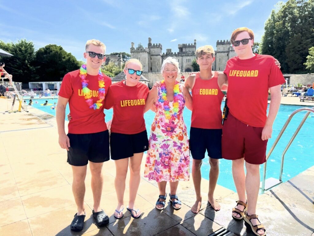 Lifeguards and volunteers in leis by the pool on Hawaiian Day
